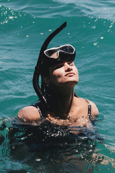 戴着黑色泳镜的女子在水中游泳